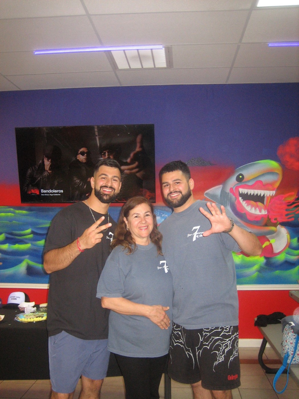 The Flores brothers with their mother at the shop's seven-year anniversary party