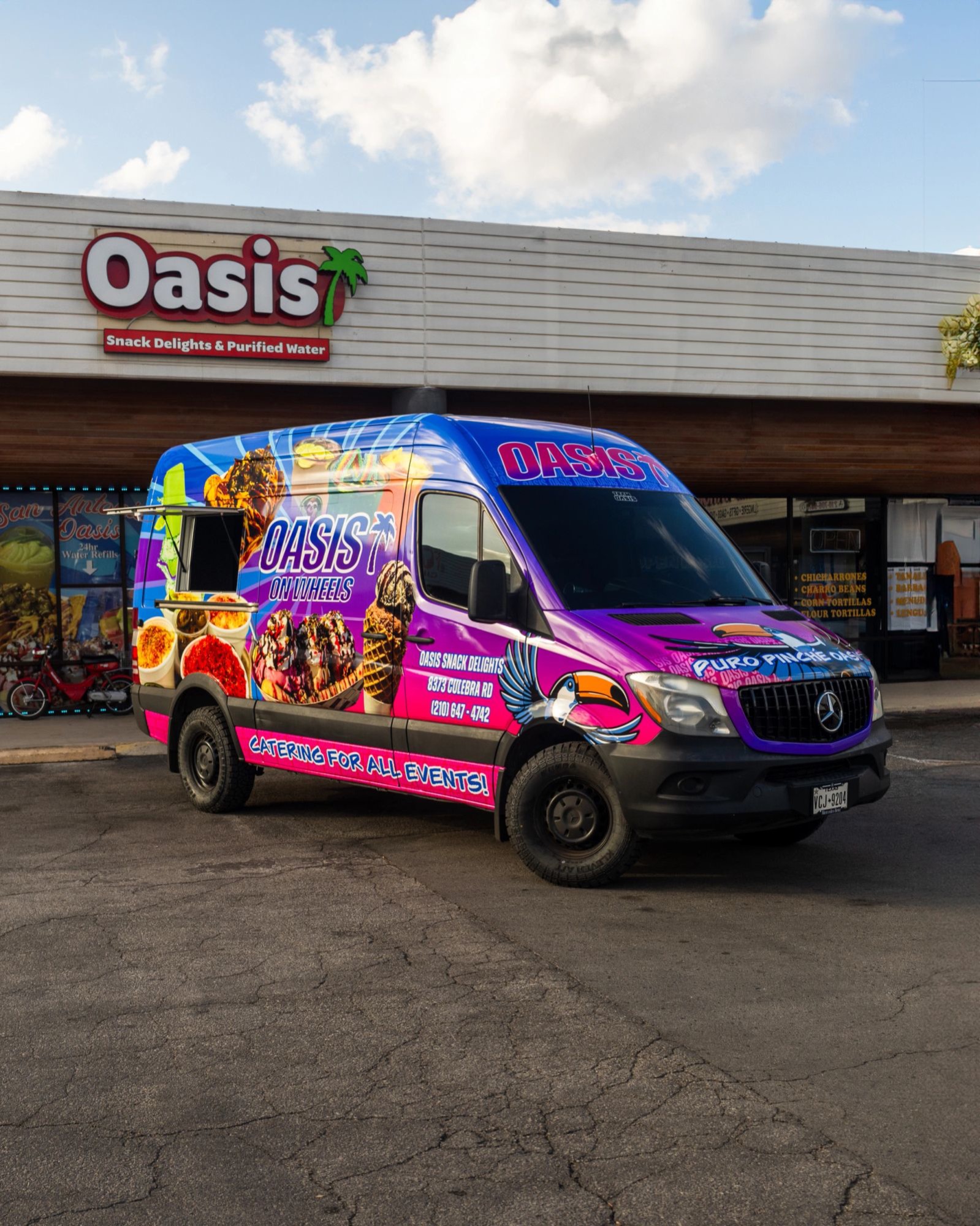 The Oasis On Wheels catering van parked outside the Oasis Snack Delights storefront on Culebra Road